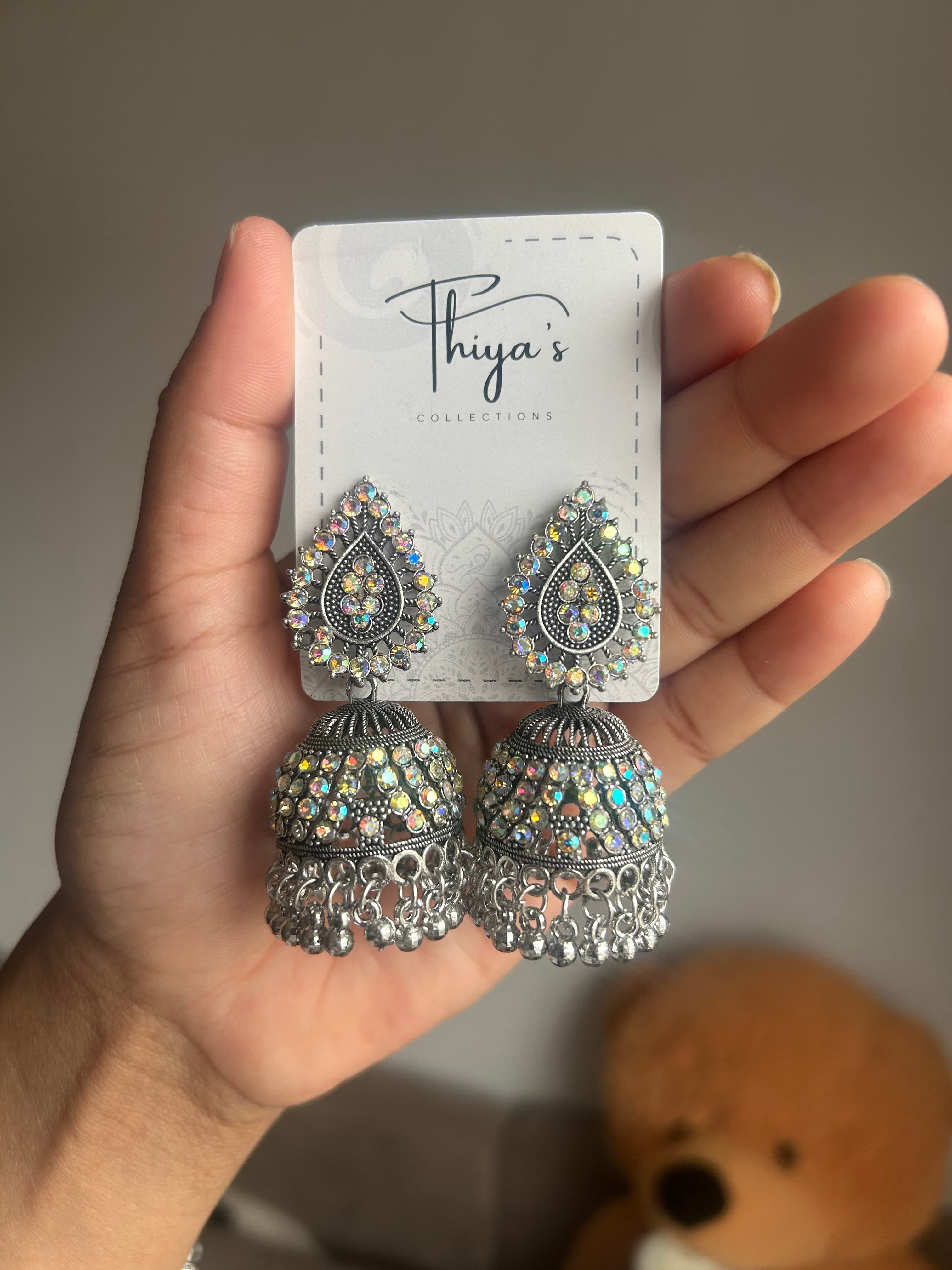 Thiya's Silver Rainbow Jhumkas mit schwarzer Silberbeschichtung und Aurora Borealis-Steinen elegante Tränenförmige Studs mit irisierenden Kristallen